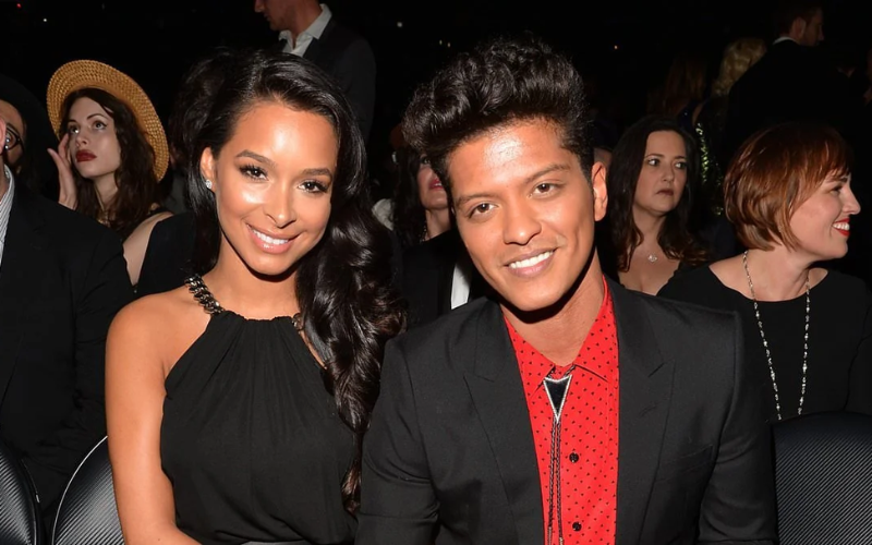 this image shows that Bruno Mars and Jessica Caban sharing a smile together in a moment of happiness, despite recent rumors about their relationship facing challenges.