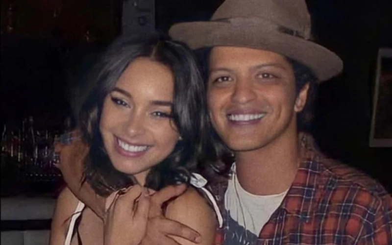 This image shows that Jessica Caban smiling warmly and sharing a hug, showcasing her friendly and loving nature, as she supports Bruno Mars in his career