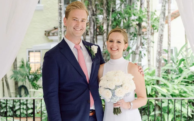 A beautiful wedding day photo of Peter Doocy and Hillary Vaughn, both smiling joyfully at the camera. The couple looks happy and radiant as they celebrate their marriage on their special day.